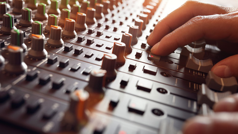 An operator makes adjustments to a soundboard. The M Resort offers full audio and visual services for meetings and events.