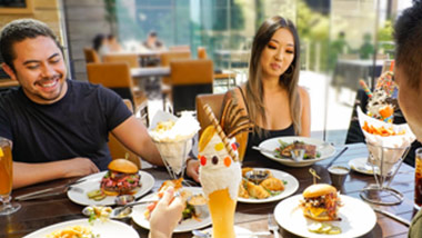 3 friends with spread of food in front of them on the table